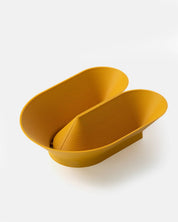 Angle view of U Bowl modern sculptural fruit bowl in yellow ochre by Cyrc